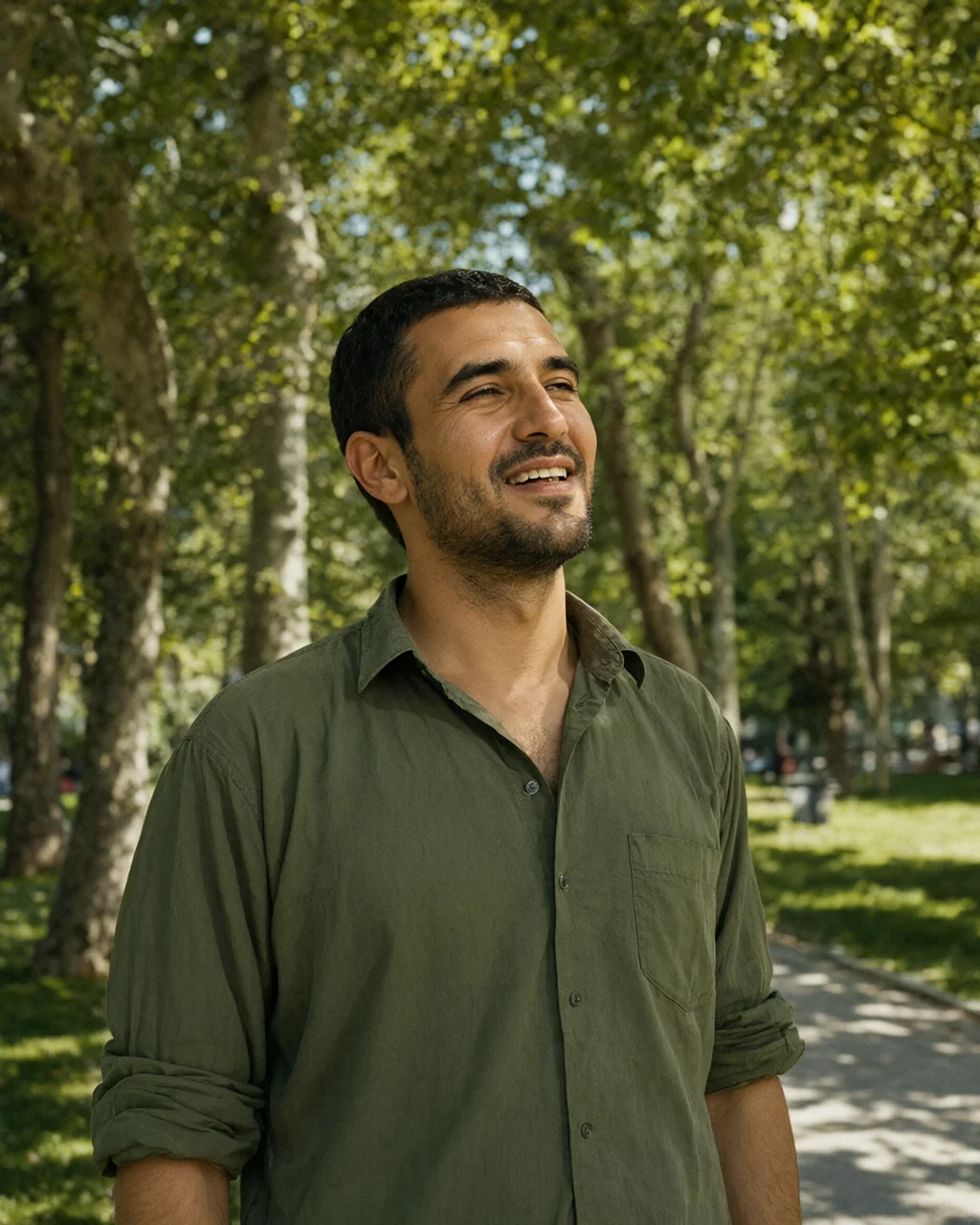 مرد جوانی که در نور آفتاب در یک پارک استانبول لبخند می‌زند